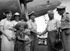 Capt Blue Young, FO Jack Slater and hostie Chaslyn Begrie being welcomed by Rev Doug Belcher and family on arrival of first TAA flight to Mornington Island, 13/7/1955